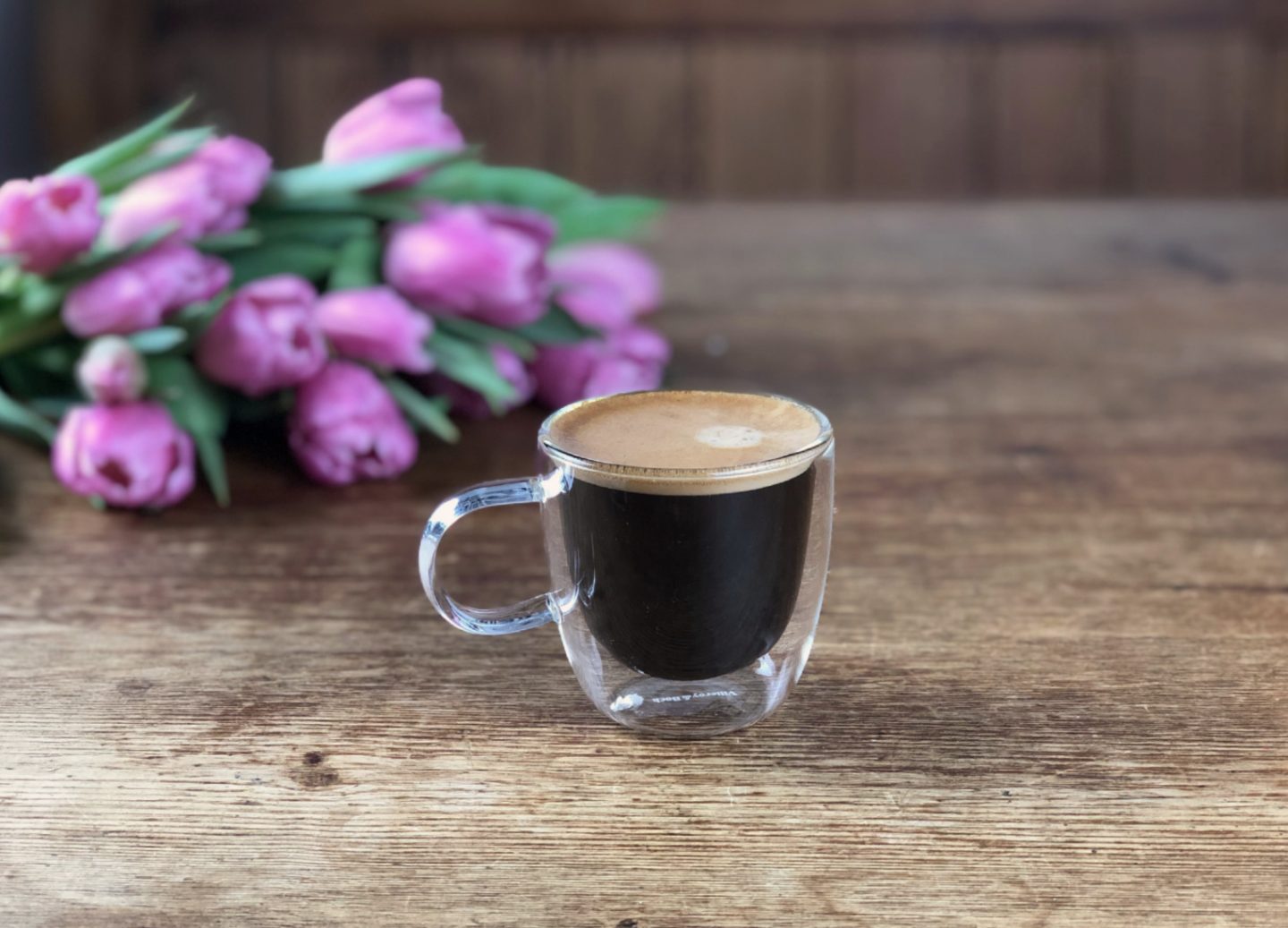Coffee and flowers on a rustic table